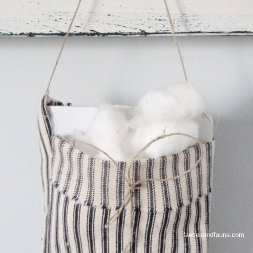 Adding cotton balls and essential oils to a DIY fabric pouch.