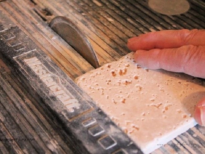 Cutting a tile on a wet tile saw.