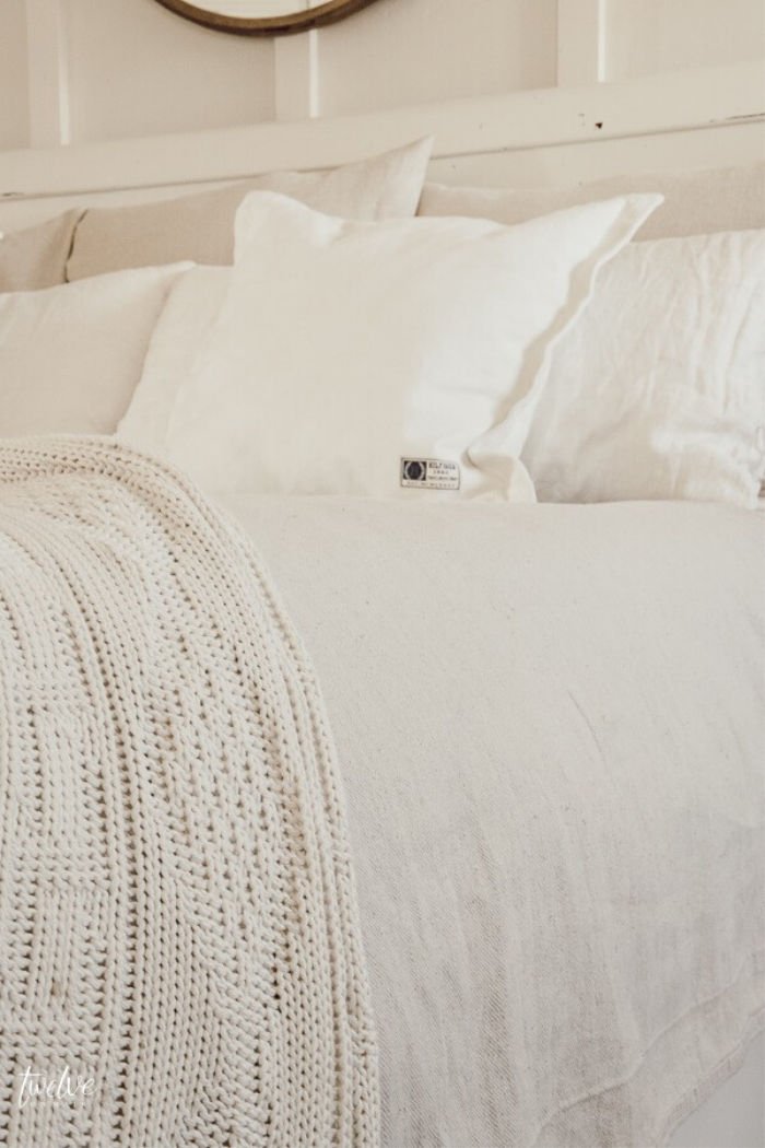 DIY drop cloth bedding hack, on the bed with white cushions and cream coloured farmhouse throw. A pretty farmhouse bed.