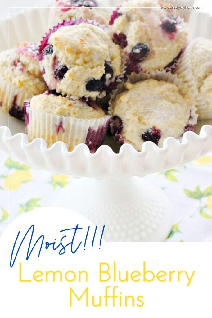 A large white pedestal bowl filled with a large mound of homemade moist lemon blueberry muffins.