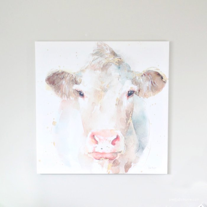 Modern Farmhouse Watercolor Cow canvas print from Photowall. Its large with pinks, grey, gold and cream.