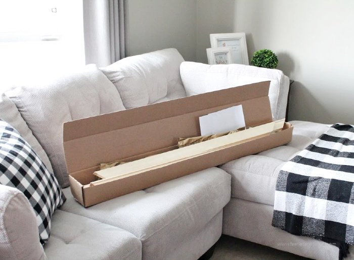 A large shipping box filled with large wooden frame, instructions, and all the supplies for a canvas print.