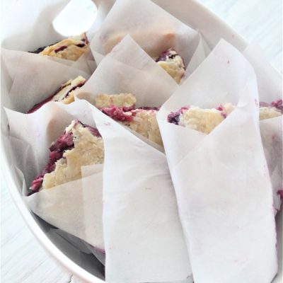 From scratch bumbleberry slab pie cut into finger size and wrapped in parchment for serving.