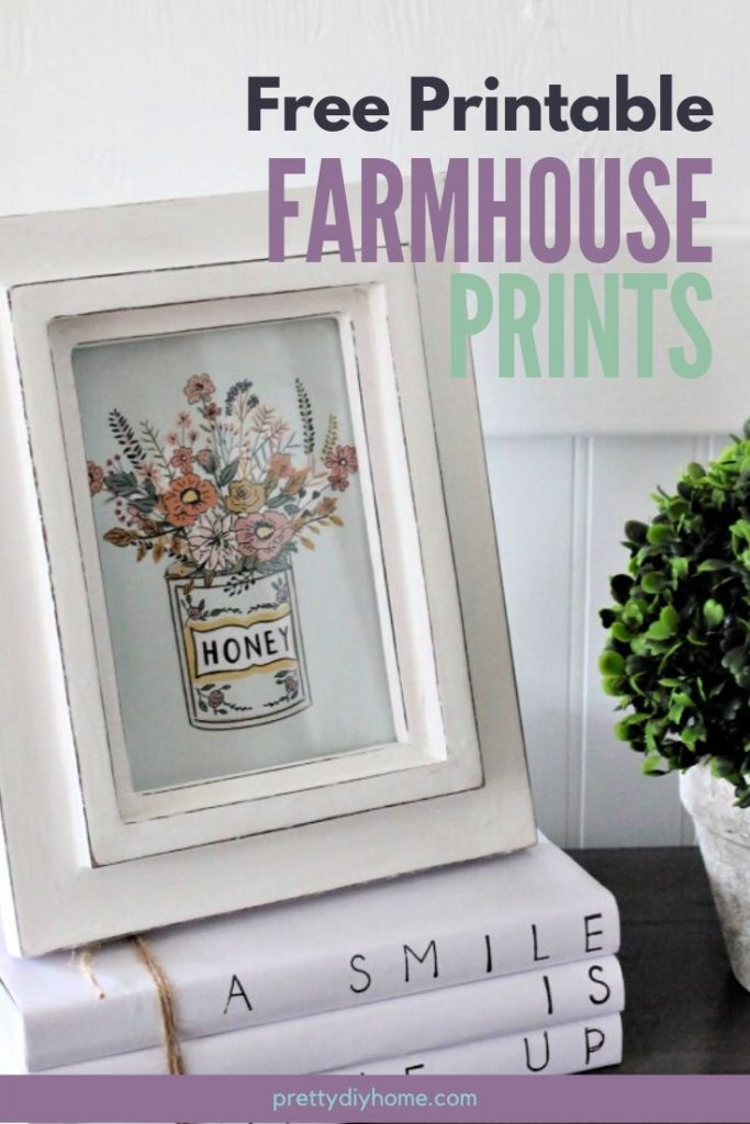 A free farmhouse floral printable in a white frame, sitting on a stack of farmhouse covered book stacks