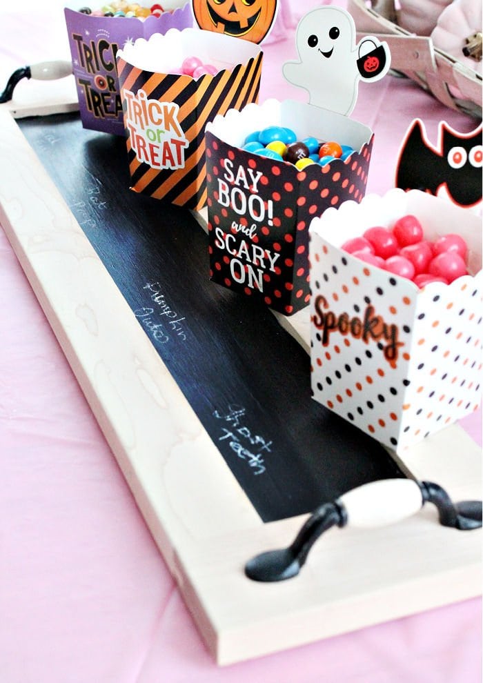 An upcycled drawer front becomes a chalk board serving tray for Halloween candy. The labels are marked on the chalkboard.