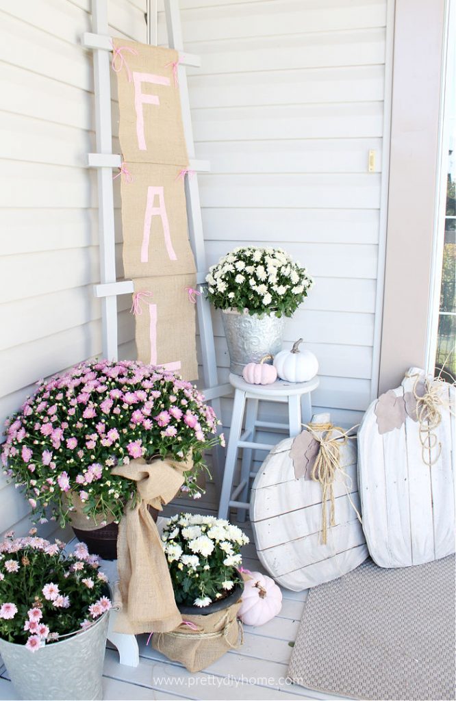 Fall front porch decor with a DIY ladder Fall burlap sign, mums and pumpkins.