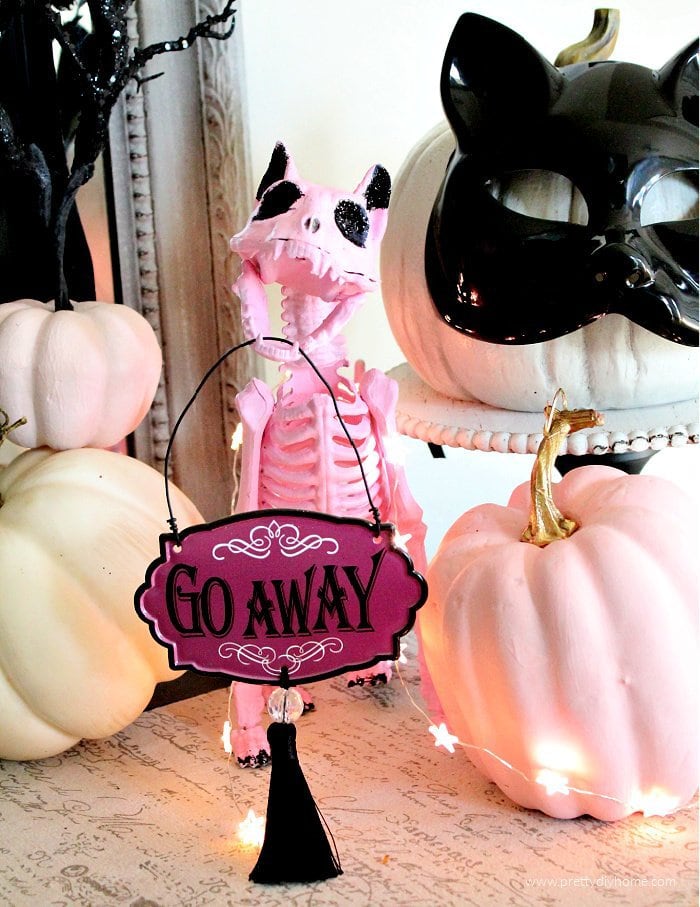 DIY Halloween cat craft of a pink cat with black sparkles, pumpkins and a haunted house chalkboard in the background.