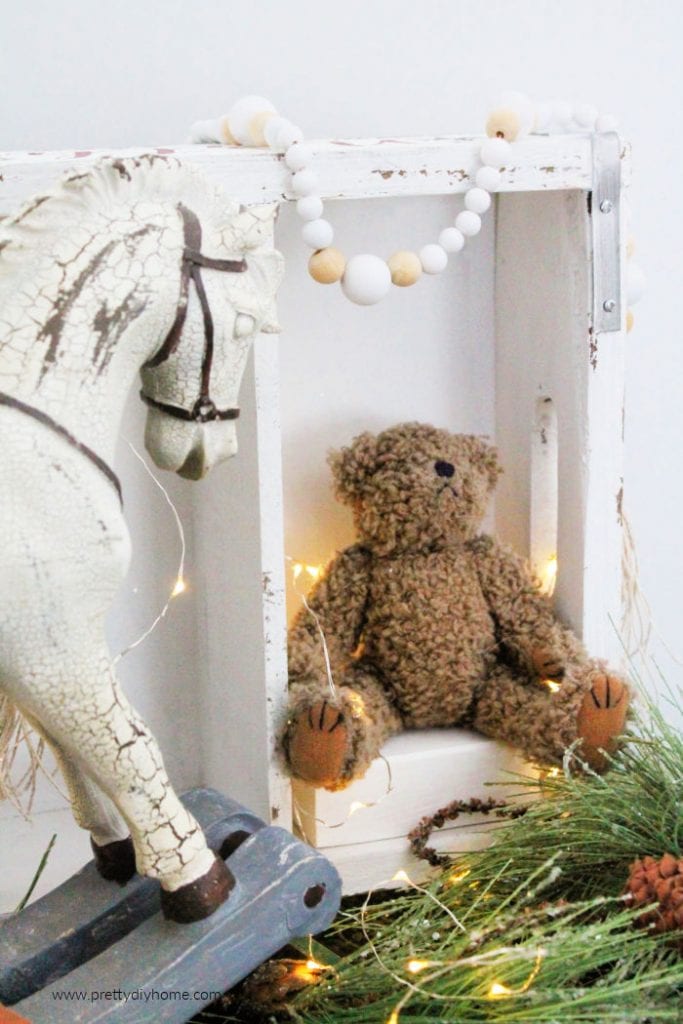 A white and natural bead Farmhouse Garland in a Christmas vignette. A pretty DIY Christmas gift idea.