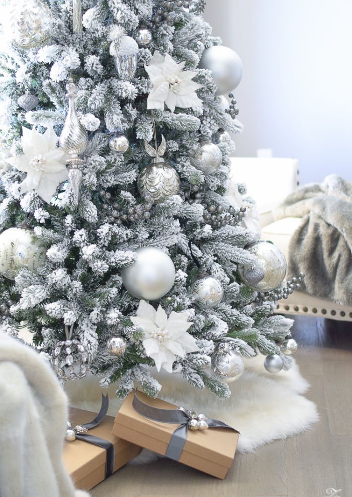 Large flocked Christmas tree with All White Christmas Decorations