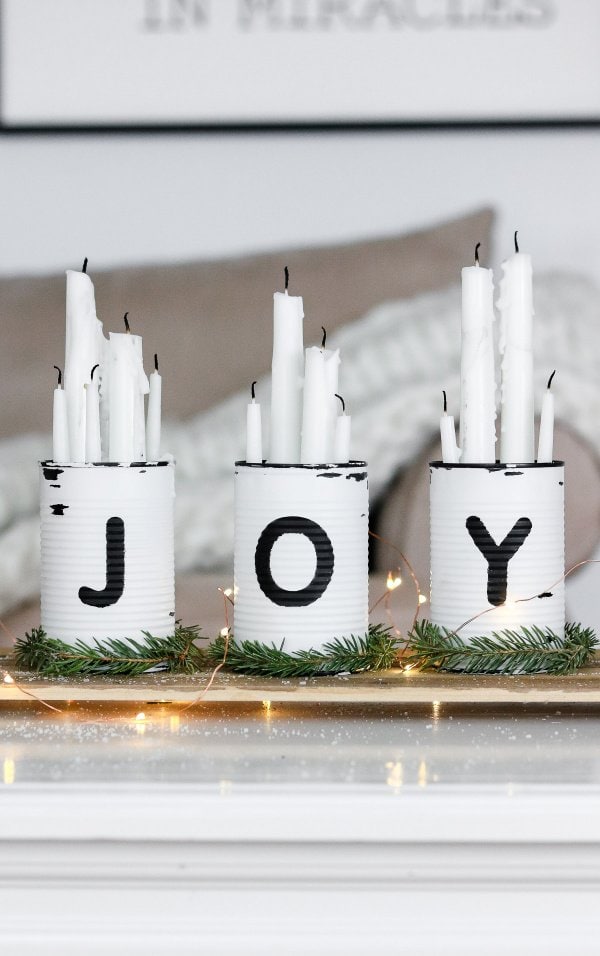 Simple centerpiece for Christmas with white cans and white candles.