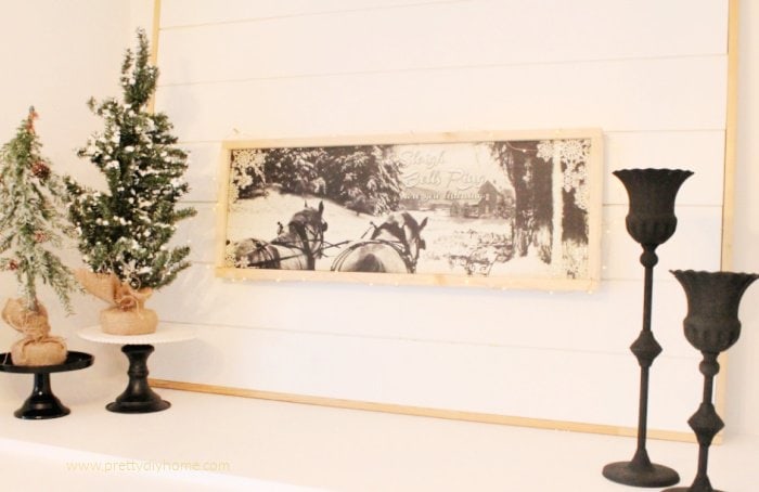 Sleighbells ring artwork in neutral colours showing two work horses pulling a large sleigh.