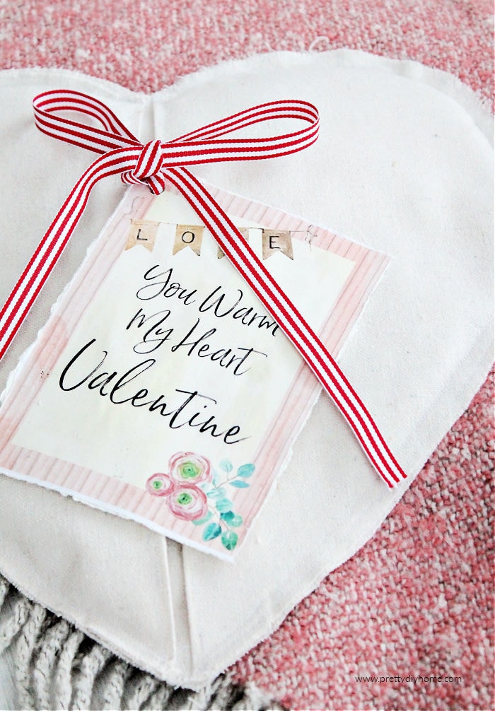 DIY Valentine Gift Heating pad in cream crop cloth with a red farmhouse ribbon and a card that says " You warm my heart Valentine"