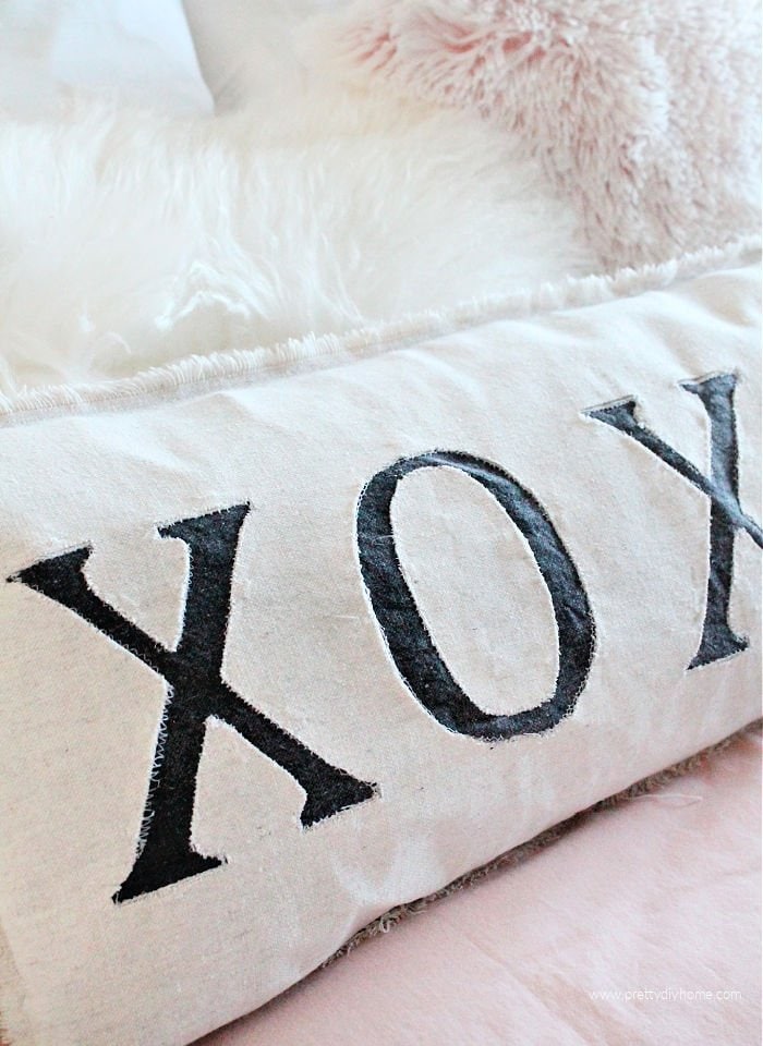 A large DIY drop cloth pillow with a series of X and Os across the front.