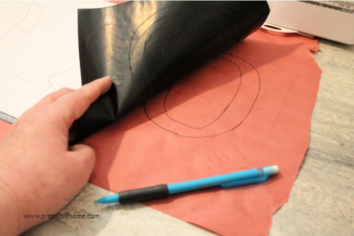 Transferring a pattern onto freezer paper using carbon paper.