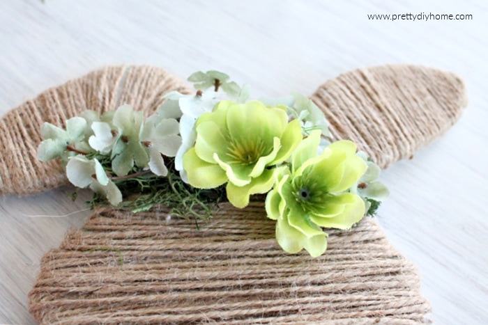 Making a floral crown for a Easter bunny using moss, soft green flowers for the background. and two large bright green flowers for a focal point.