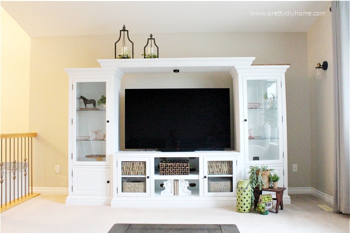 Fixed and painted white DIY Entertainment center makeover, in white with storage baskets.`