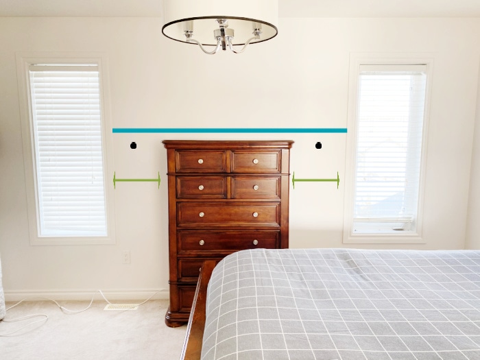 Measuring the placement of diy peg rail shelving in a bedroom around a dresser.