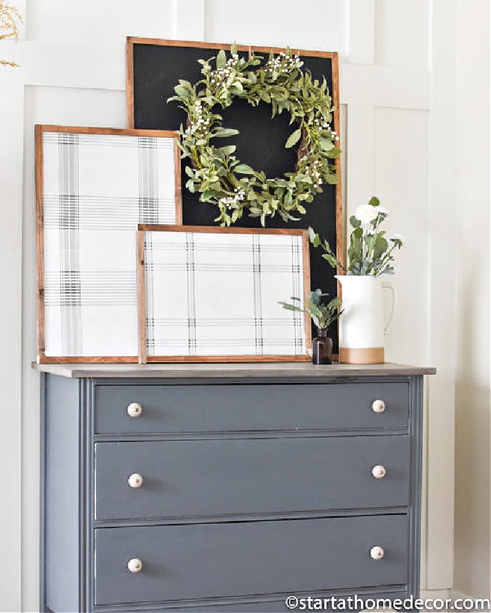 Two DIY plaid art frames with wood frames, and a chalkboard background. The artwork is arranged on top of a grey dresser.