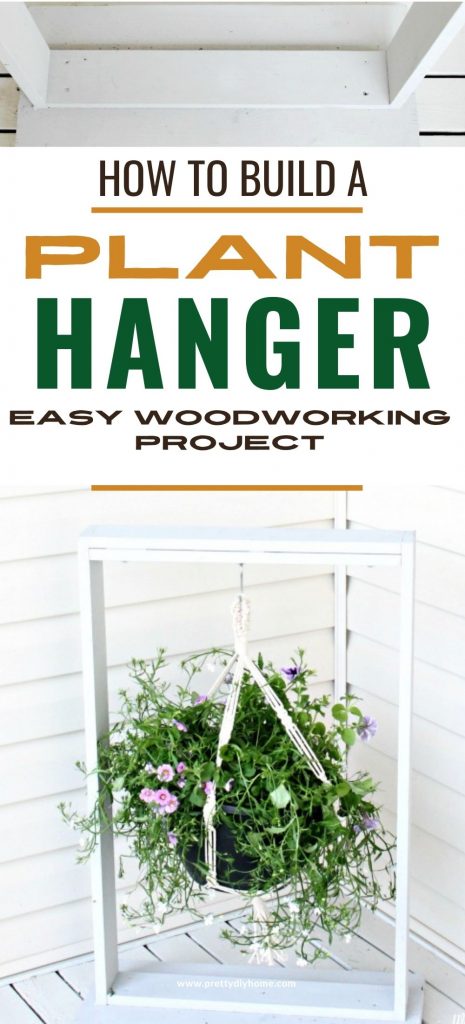 A large DIY hanging plant stand built out of scrap wood. It is painted white and it holding a large flowered plant. The plant hanger is sitting on the front porch beside the front door.