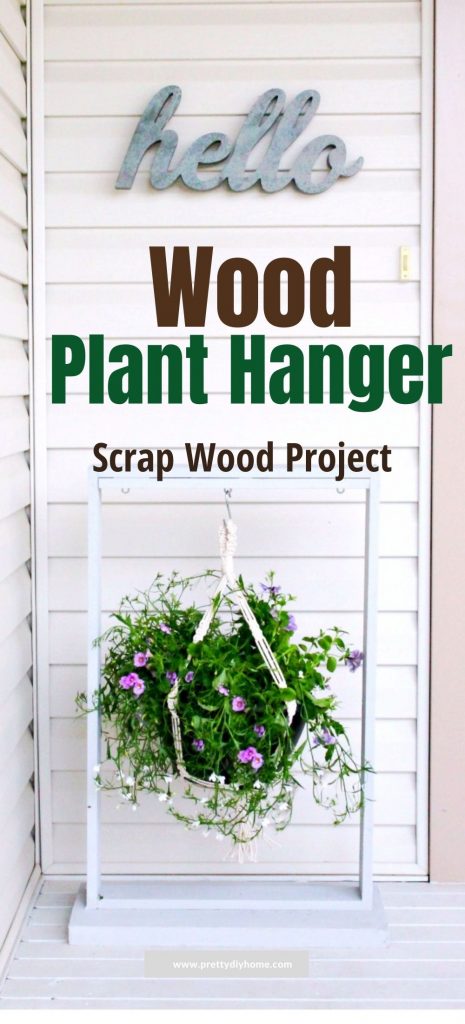A large diy planter hanger sitting outdoor on the front porch. The plant hanger is made out of wood, painted white and has a large flower pot of petunias and vines hanging from it.