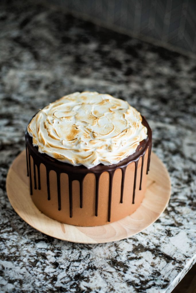 A whole entire S'mores cake with chocolare cake overed with chocolate icing, then drizzled with chocolate and then covered with melted toasted marshmallows.