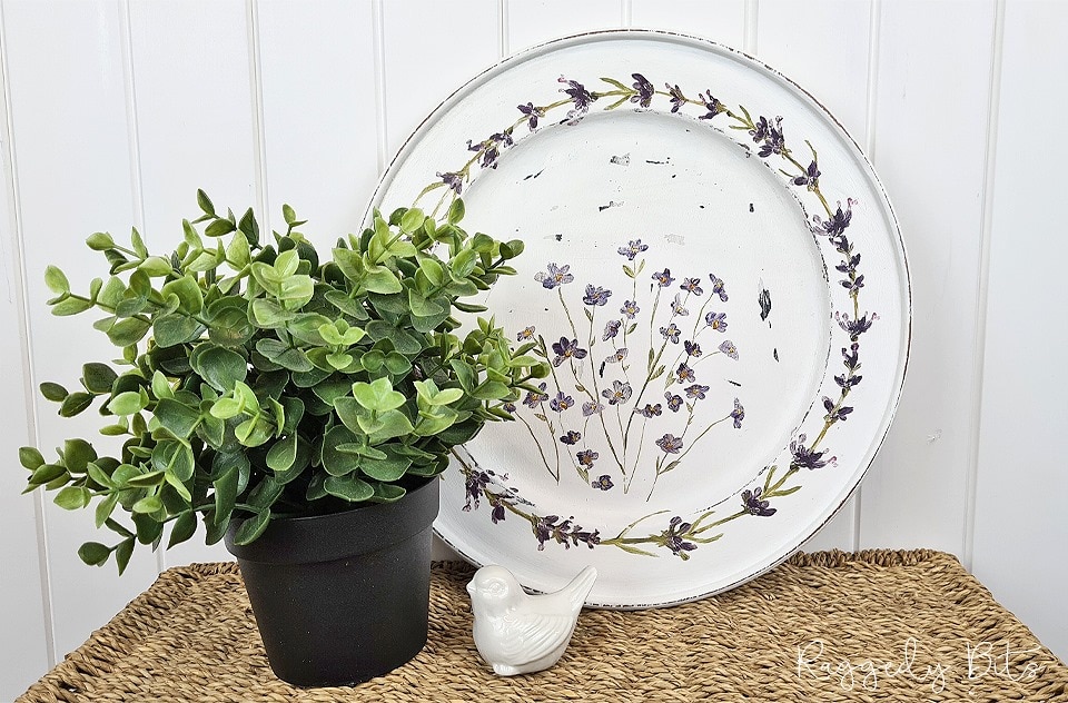 A white wooden plate covered in transfer lavendar flowers. An easy farmhouse upcycle for home decor