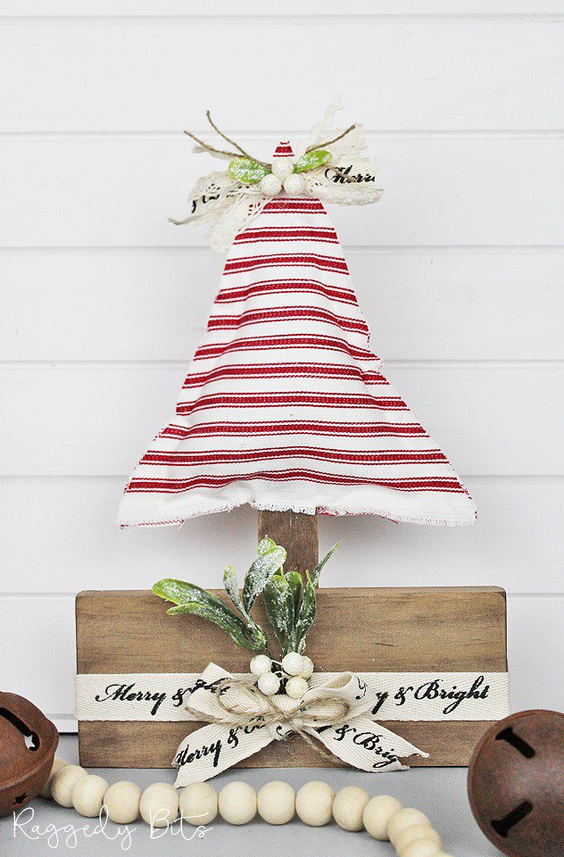 A red and white ticking fabric Christmas tree with wooden stand.