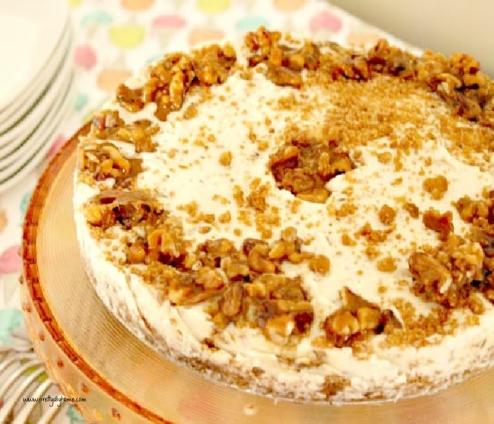 A full sized maple walnut ice box cake with forks and plates sitting beside it.