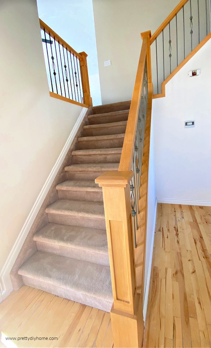 A new stair bannister and railing in golden oak with gunmetal spindles and very large posts