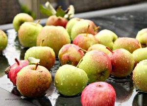 Fresh apples for making an apple butter recipe to can. The apples are small with bright red and green skins.