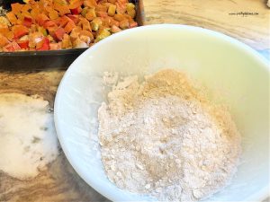 A large mixing bowl with oatmeal, flour and brown sugar. The crumb layer for rhubarb crisp.