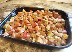 Rhubarb coated in flour, sugar and cinnamon inside a baking dish. The rhubarb filling for a rhubarb crisp