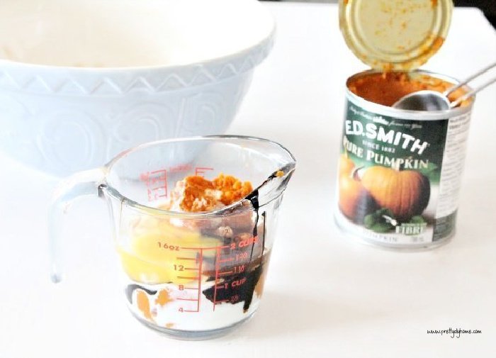 Mixing canned pumpkin puree and wet ingredients together for a pumpkin scone recipe.