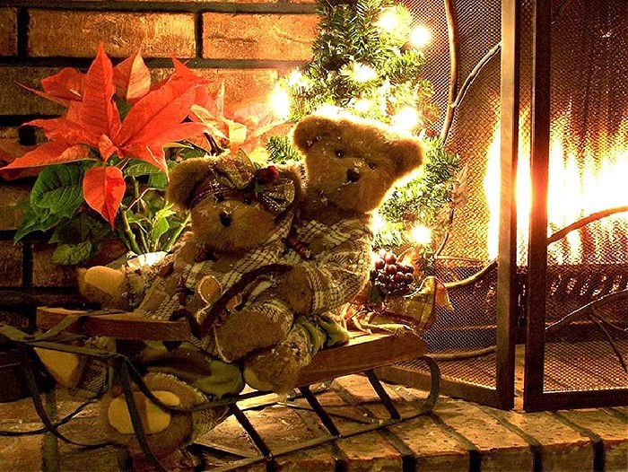 Two vintage toy teddy bears on a vintage sleigh as Christmas decor for a fireplace