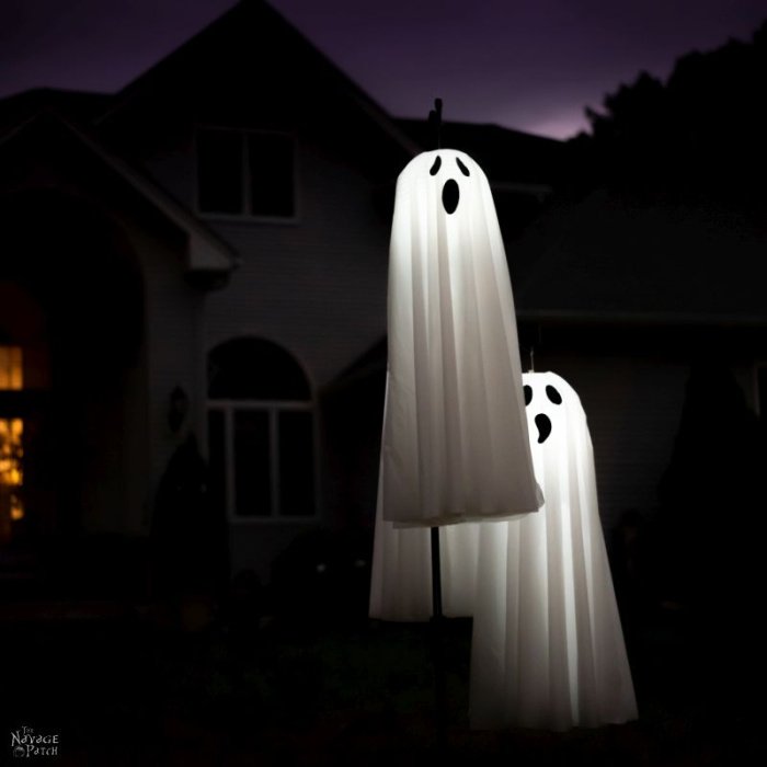 Two lit up outside ghosts with howling faces. One ghost is floating.