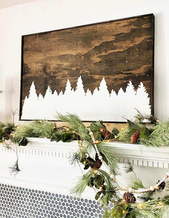 A large rustic diy wood sign in dark walnut stain with a gorgeous white forest silhouette.