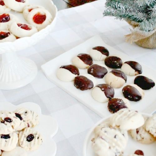 A display of different varieties of shortbread cookie recipes, there is shortbread dipped in chocolate, cranberry pistachio shortbread cookies, shortbread jam cookies and chocolate chip pecan shortbread cookies.