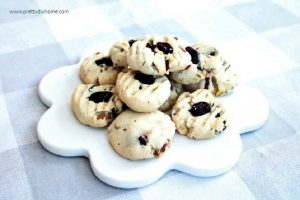 A white tray stacked high with shortbread cookie recipe that includes cranberry and pistachios.