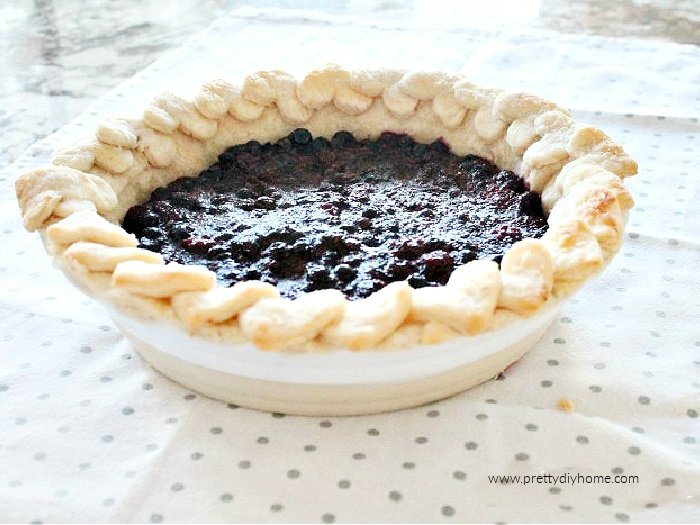 A baked mixed berry pie with Valentine shapes encircling the crust.