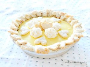 A mixed berry pie covered with lemon custard and sugared Valentine shaped bits of pie crust and whipping cream..