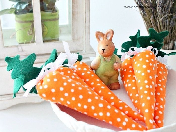 A simple Easter craft, sew some adorable stuffed carrots. The carrots are orange polka dot fabric with a cute Easter bunny guarding in the background.