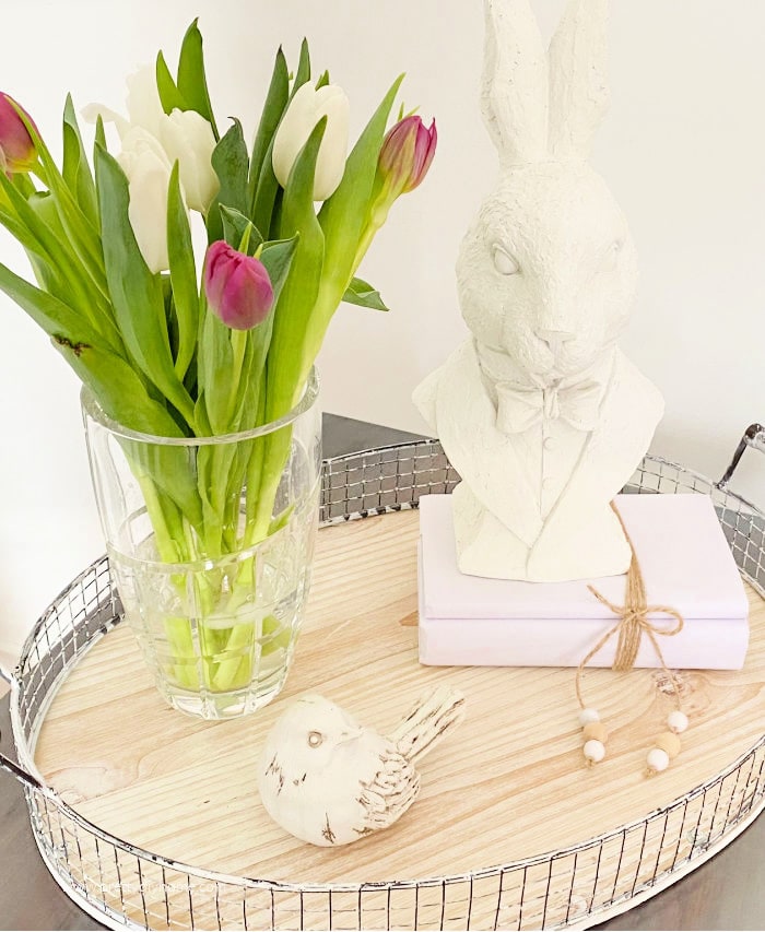 Fresh tulips that have been cut under water, had their lower stems removed, and placed in ice water to prevent drooping and make them last longer. The tulips are fresh and standing in a tall crystal vase.