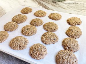 A tray of fresh baked carrot cookies sitting on parchment paper.