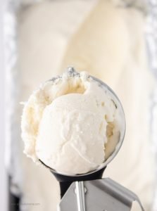 A large scoop of vanilla ice cream. You can see the remaining ice cream in the pan underneath.