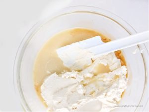 Folding whipped heavy cream into a mixture of condensed milk and vanilla.