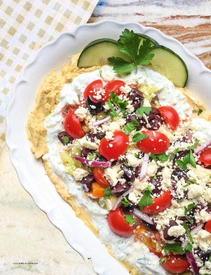 Layered Greek dip with hummus, tzatziki, tomatoes, cucumber, Kalamata olives, red onion, and feta cheese.