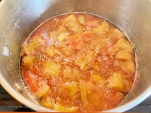 A saucepan filled with rhubarb sauce that is cooking.