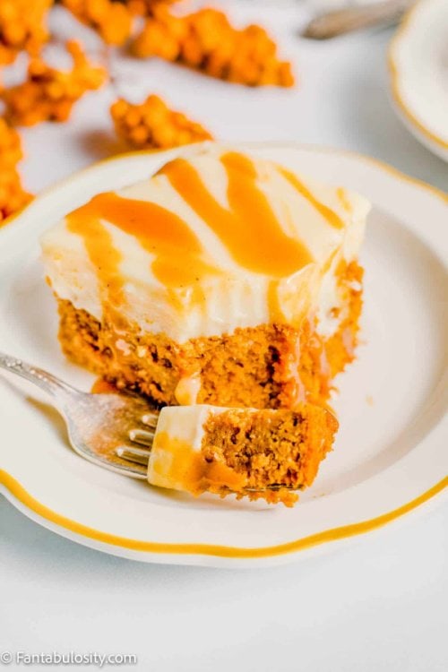 Pumpkin pie poke cake that's been covered with vanilla pudding, and sprinkles