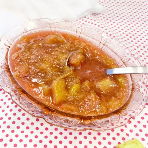 Homemade rhubarb sauce being served in a pink bowl.