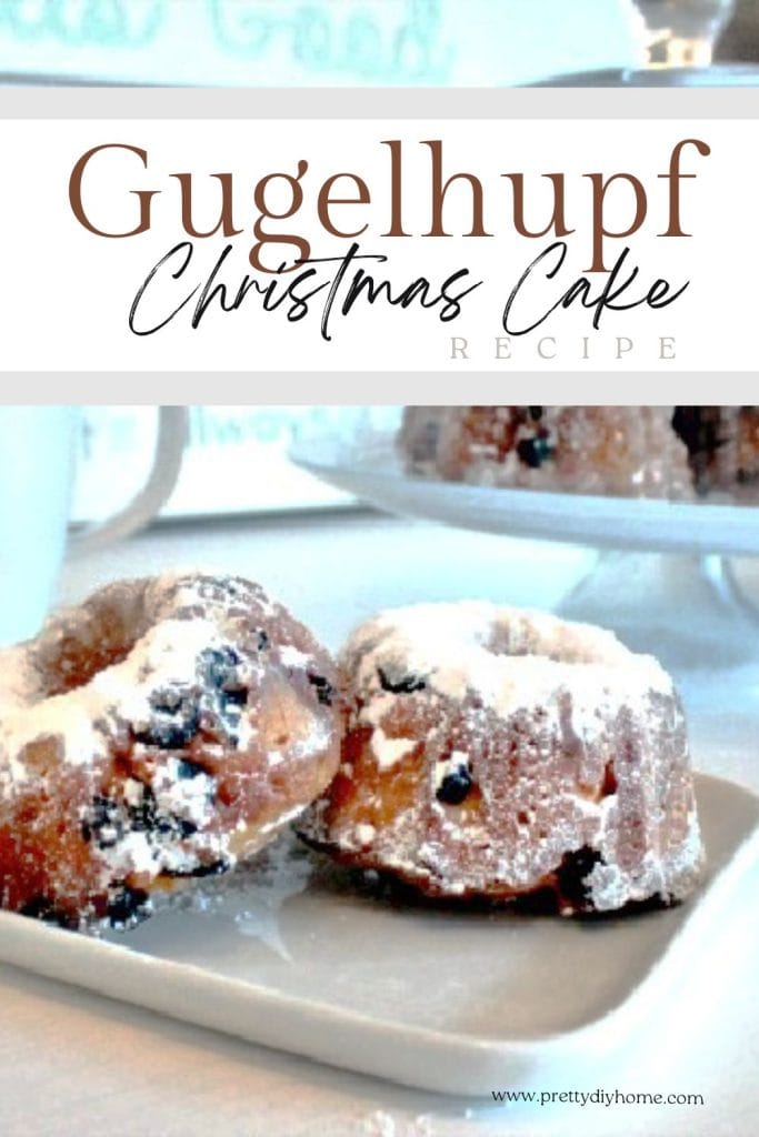 Two small gugelhupf cakes sitting on a square plate. The two Christmas desserts are covered with powdered sugar and you can see lots of raisins and currants inside of the cake.